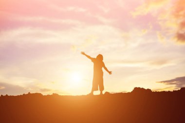 Güzel bir arka plan için dua eden bir kadın silueti.