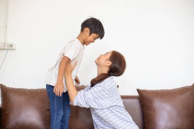Oturma odasında mutlu bir Asyalı aile, evde oynayan bir ailenin mutluluk zamanı, anne ve bebek bir arada mutluluk, mutlu aile kavramı ve çocuklar için becerileri güçlendirmek için aktiviteler yaratmak.. 