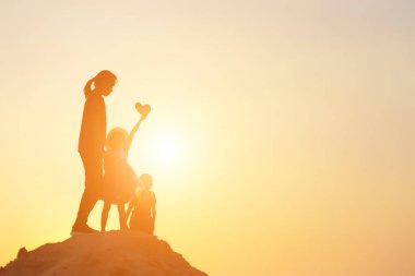 Mutlu bir ailenin silueti ve mutlu gün batımı