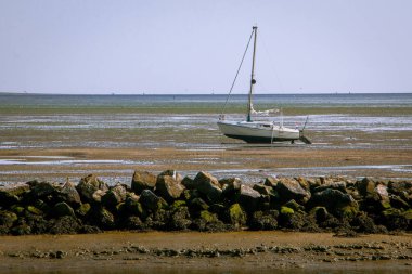 Wadden Denizi, yüksek ve düşük gelgit ya da başka bir deyişle ebb ve akış büyüleyici etkileşimi ile, deniz topraklarında büyük bir görünüm verir, tekneler tekrar yelken yeni akışı bekliyor, Schiermonnikoog alınan resim