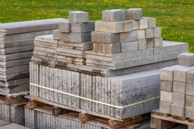 Ahşap palet üzerinde gri renklerde yığılmış kaldırım taşları ve kaldırım taşları