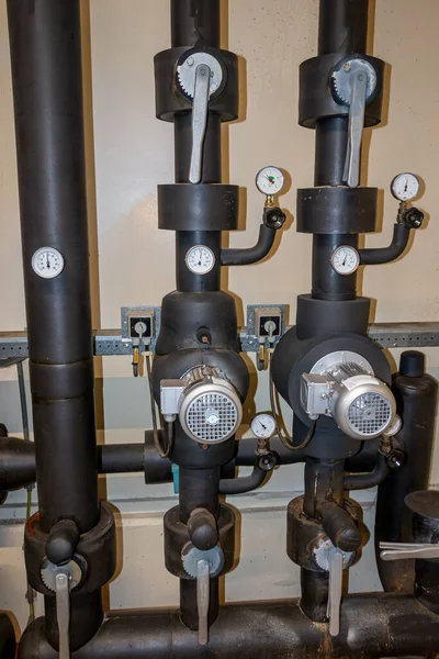 Central heating system in an industrial building, with insulated pipes, manual valves and pumps