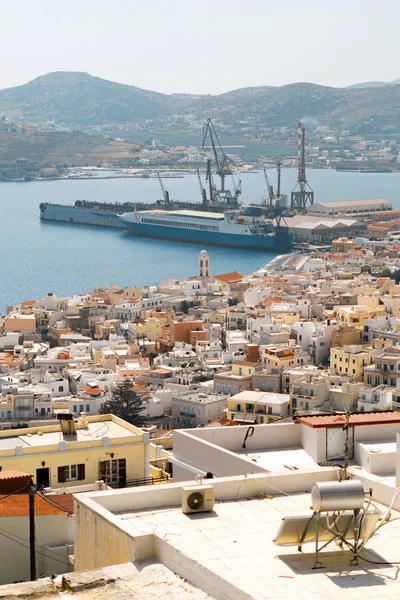 Panoramik manzaralı kıyı Avrupa tatil beldesi güneşli yaz günü. Düşük katlı binalar, bağlantı noktası ile gemi, Ege Denizi ve dağlar içinde belgili tanımlık geçmiş. Bakış açısı Hermoupolis şehir: Syros Adası, Kiklad Adaları, Yunanistan.