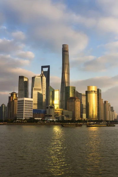 Modern Asya şehir şehir merkezinde ile sunscrapers gün batımında. Güneş yanıp söner ve gökdelenler duvarlarının cam yüzeyleri yansıtır. Shanghai, Çin.