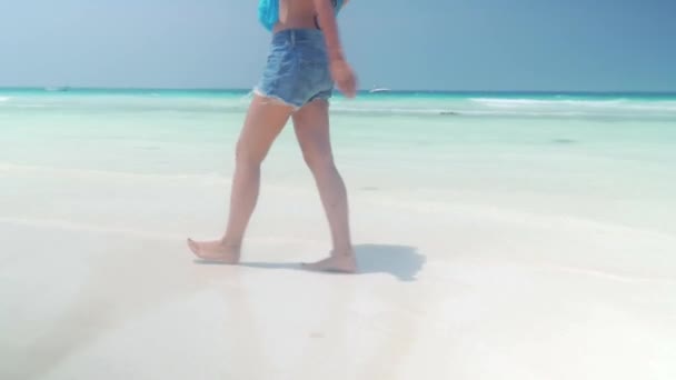 Menina descalça caminha na praia de areia ao longo do oceano — Vídeo de Stock