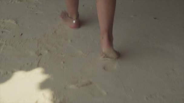Primer plano de las piernas femeninas caminando en la playa de arena — Vídeo de stock