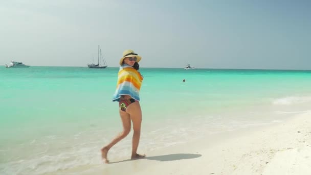 Barefoot girl walks on sandy beach along ocean — Stock Video