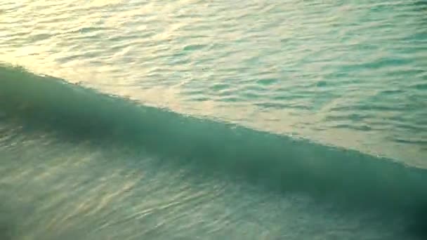 Mořské vlny válcování na písečné pláži při západu slunce — Stock video