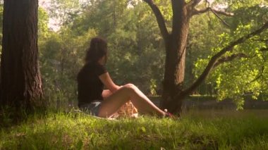 Genç kadın parkta smartphone ve tablet kullanır