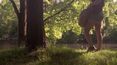 Ağaç Parkı yakınındaki çimenlerin üzerinde genç kadın oturur