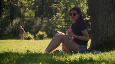 Genç kadın smartphone kullanır ve durgun su içer