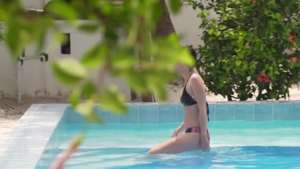 Joven mujer caucásica sale de la piscina — Vídeo de stock