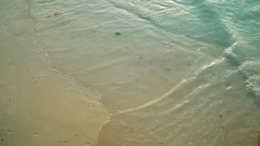 Kumsalda gün batımında inişli çıkışlı dalgalar deniz