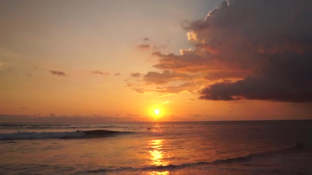 Surfistas passeio ao pôr-do-sol laranja sobre o Oceano Índico — Vídeo de Stock