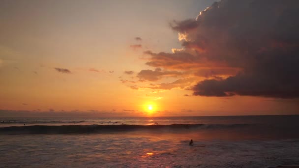 Surfistas passeio ao pôr-do-sol laranja sobre o Oceano Índico — Vídeo de Stock