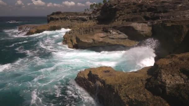 Oceaan water breekt op rotsen op heldere zonnige dag — Stockvideo