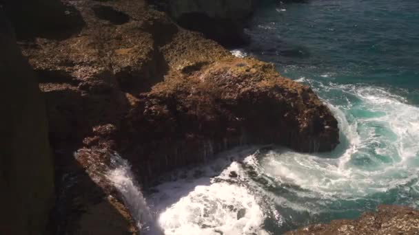 Meerwasser bricht an sonnigem Tag an Felsen — Stockvideo