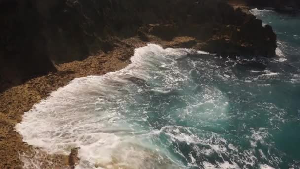 El agua del océano se rompe en las rocas en un día soleado brillante — Vídeos de Stock
