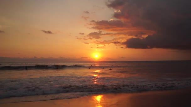 Surfistas passeio ao pôr-do-sol laranja sobre o Oceano Índico — Vídeo de Stock