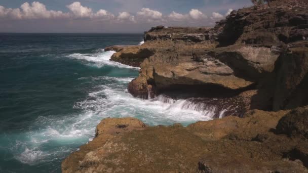 Oceaan water breekt op rotsen op heldere zonnige dag — Stockvideo