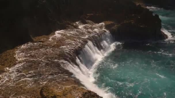 El agua del océano se rompe en las rocas en un día soleado brillante — Vídeos de Stock