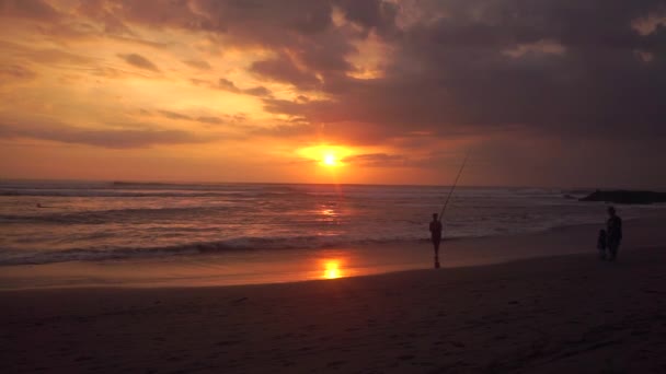 Visser en zoon op het strand bij zonsondergang — Stockvideo