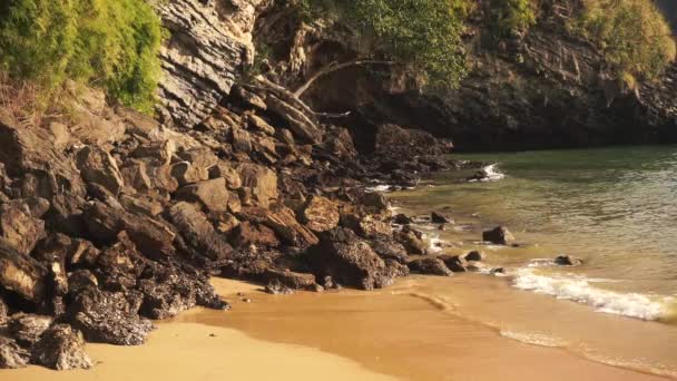 Θαλασσινό νερό πλένει τις πέτρες στην αμμώδη παραλία — Αρχείο Βίντεο