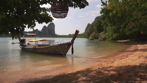 Long tail boat near sandy beach with swing. — Stock Video