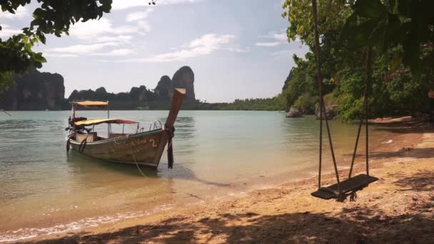 Barco de cauda longa perto de praia de areia com balanço . — Vídeo de Stock