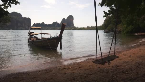 Bateau longue queue près de la plage de sable avec balançoire . — Video