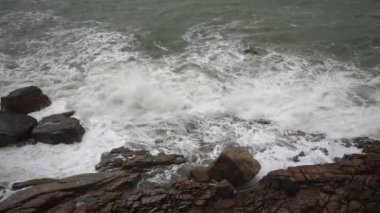 Büyük fırtına dalgaları yavaş çekimde kayalara çarpıyor.