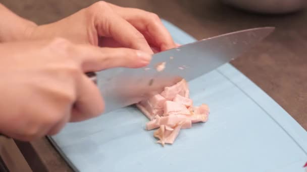 Junge Hausfrau schneidet Stück geräucherten Schweineschinken — Stockvideo