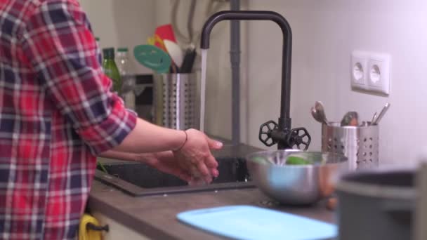 Mujer joven lava verduras en fregadero de cocina — Vídeos de Stock