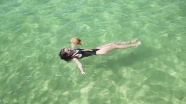 Kız berrak renkli şeffaf suda yüzer