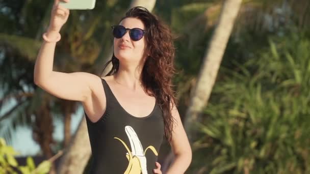 Gelukkige vrouw maken selfie op het strand — Stockvideo