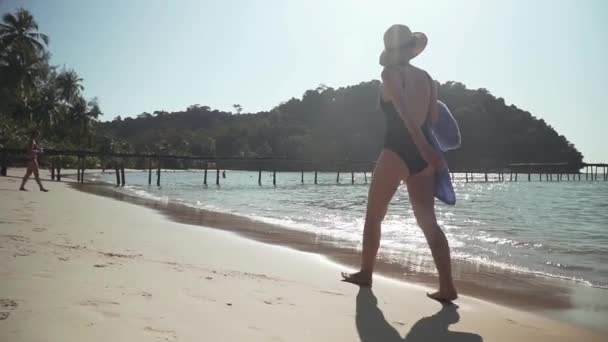 Jonge vrouw loopt langs zandstrand aan zee — Stockvideo