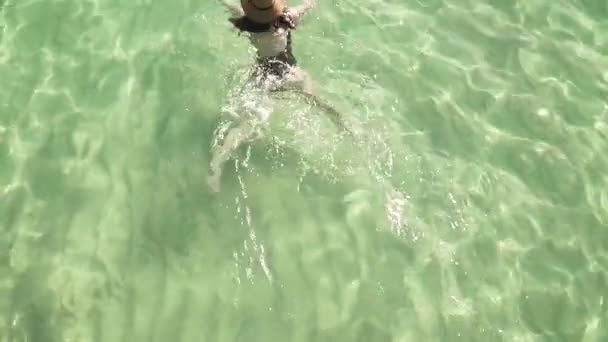 Girl swims in clear colorful transparent water — Stock Video