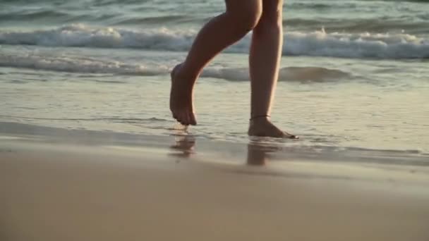 Mujer caminando en la playa al atardecer piernas de cerca — Vídeos de Stock