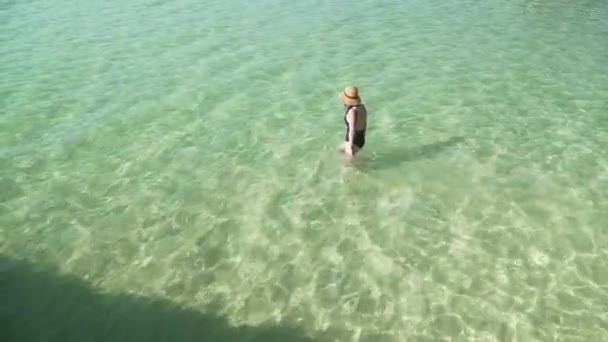 Mujer entra en agua colorida transparente para nadar — Vídeo de stock