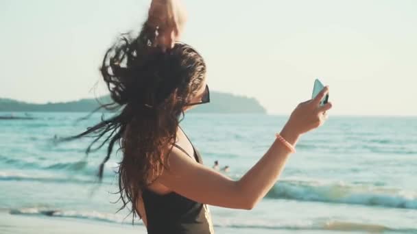 Szczęśliwa kobieta robi selfie na plaży — Wideo stockowe