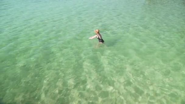 Frau betritt transparentes buntes Wasser zum Schwimmen — Stockvideo