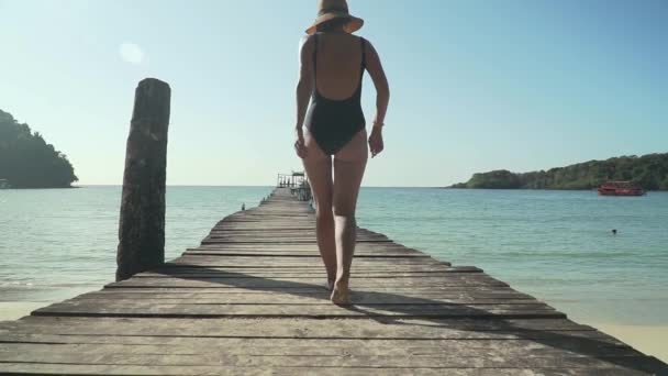 Mulher caminha em molhe de madeira na praia tropical — Vídeo de Stock