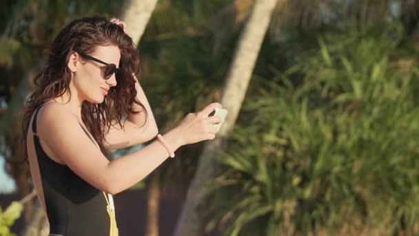 Gelukkige vrouw maken selfie op het strand — Stockvideo