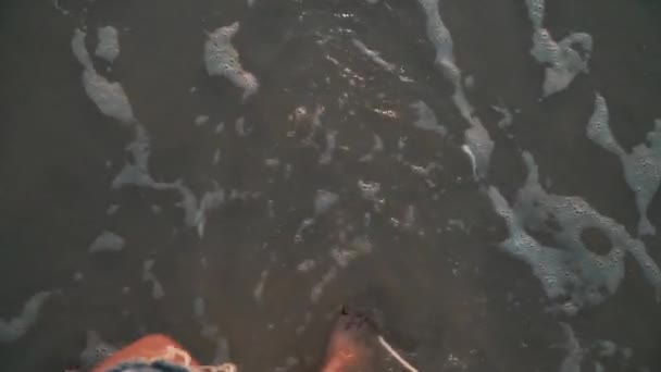Top View close-up dames benen in zee bij zonsondergang — Stockvideo