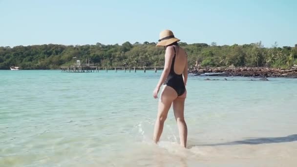 Young caucasian woman happily runs into sea water — Stock Video