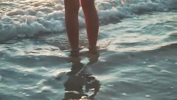 夕日の足のクローズアップでビーチを歩く女性 — ストック動画