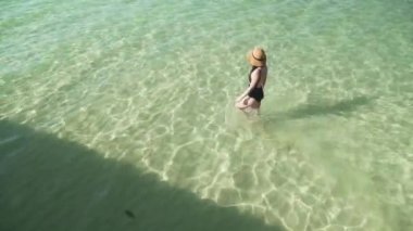 Kadın yüzmek için şeffaf renkli suya girer