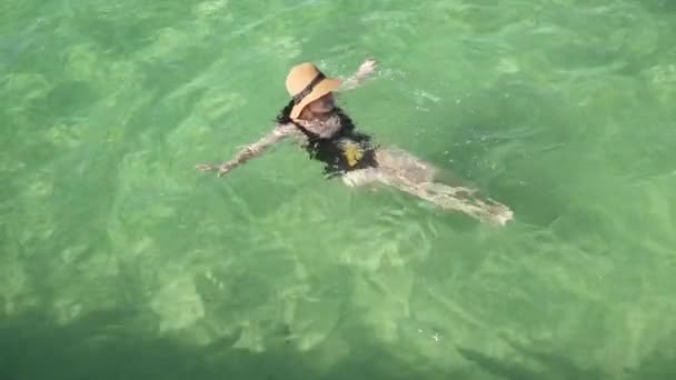 소녀는 맑고 다채로운 투명 한 물에 수영 — 비디오