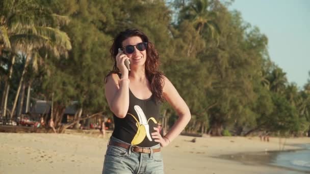 Šťastná žena volá a mluví na pláži — Stock video