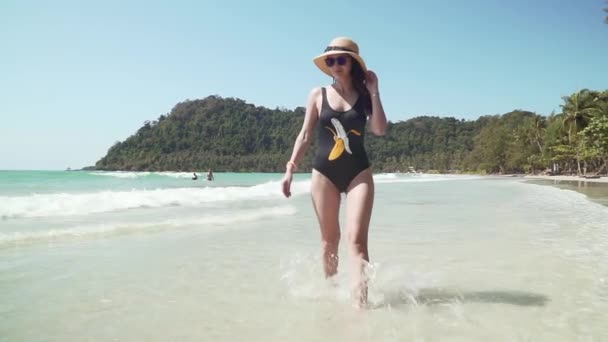 Genç kadın deniz yoluyla kumlu plaj boyunca yürüyor — Stok video